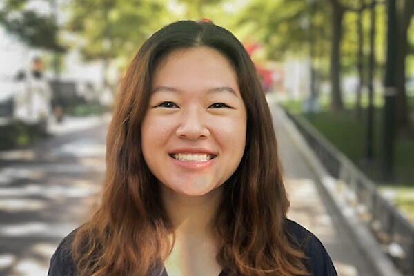 Person with long brown hair smiles into the camera.