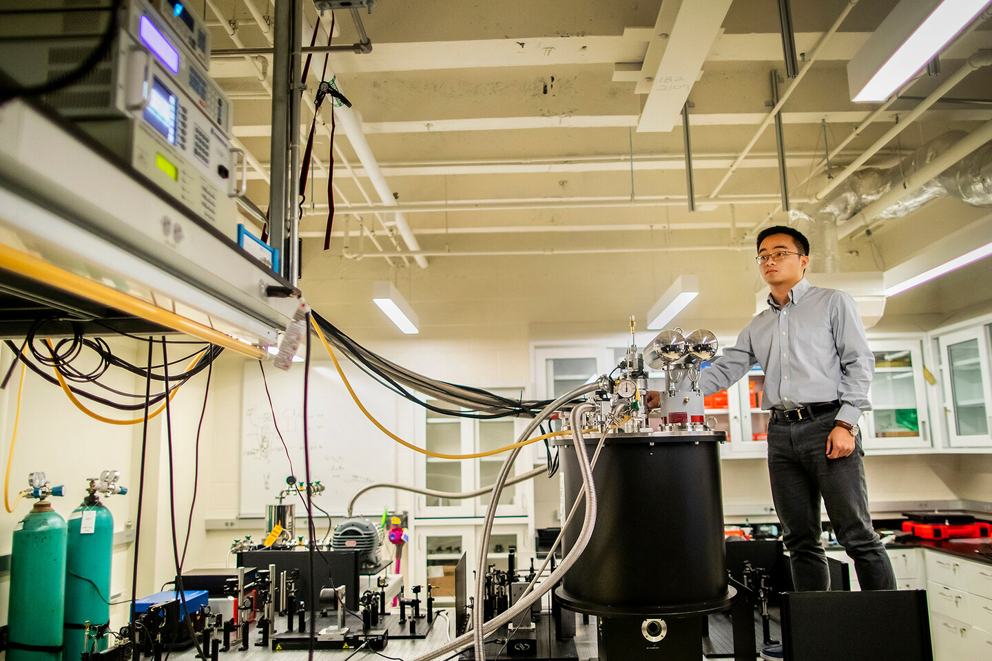 a person looking at lab equipment while adjusting another device
