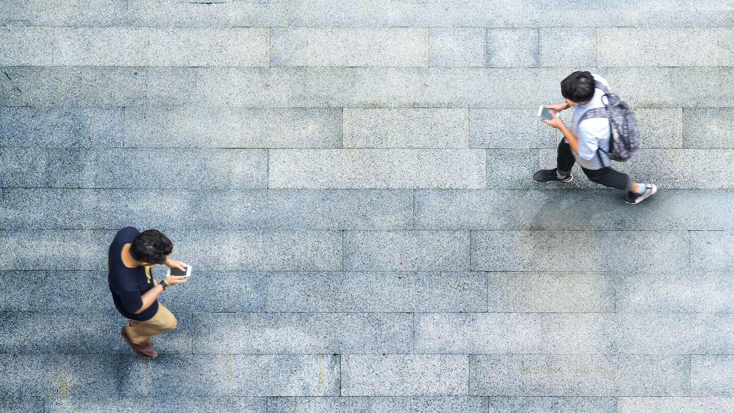 two people walking with phones