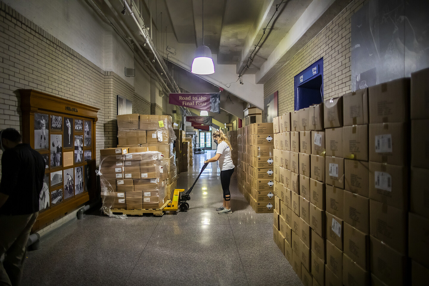 a person unloading boxes from a forklift in a hallway