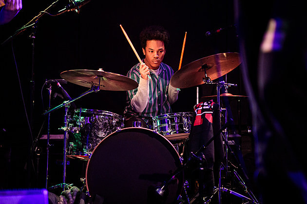 Man hold drumsticks poised to strike