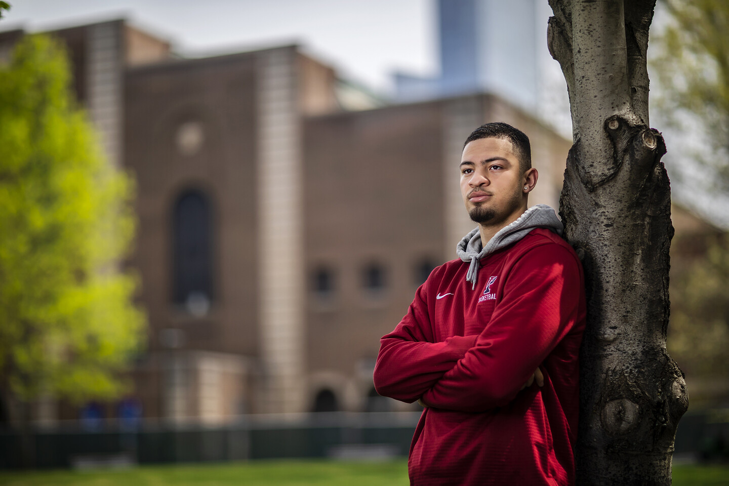 Jelani Williams leans against a tree outside the Palestra, looking into the distance.