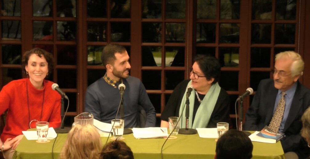 Four people sitting at a table speaking