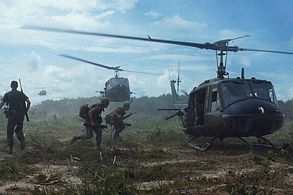 Soldiers run toward a helicopter during the Vietnam War.