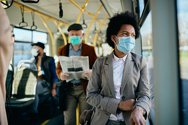 People on a commuter vehicle with face-coverings on
