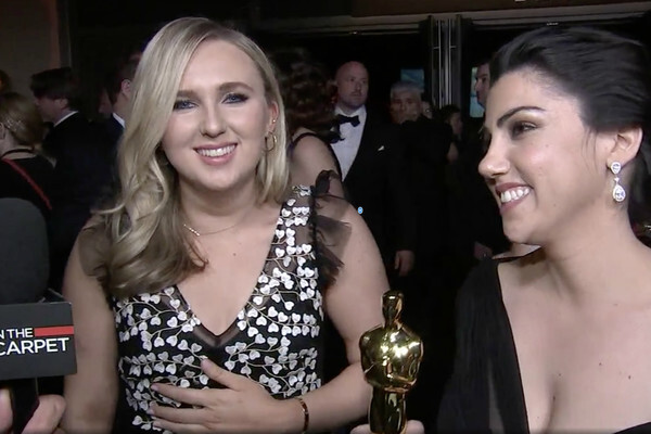Claire Sliney standing next to another person who is holding an Oscar statue