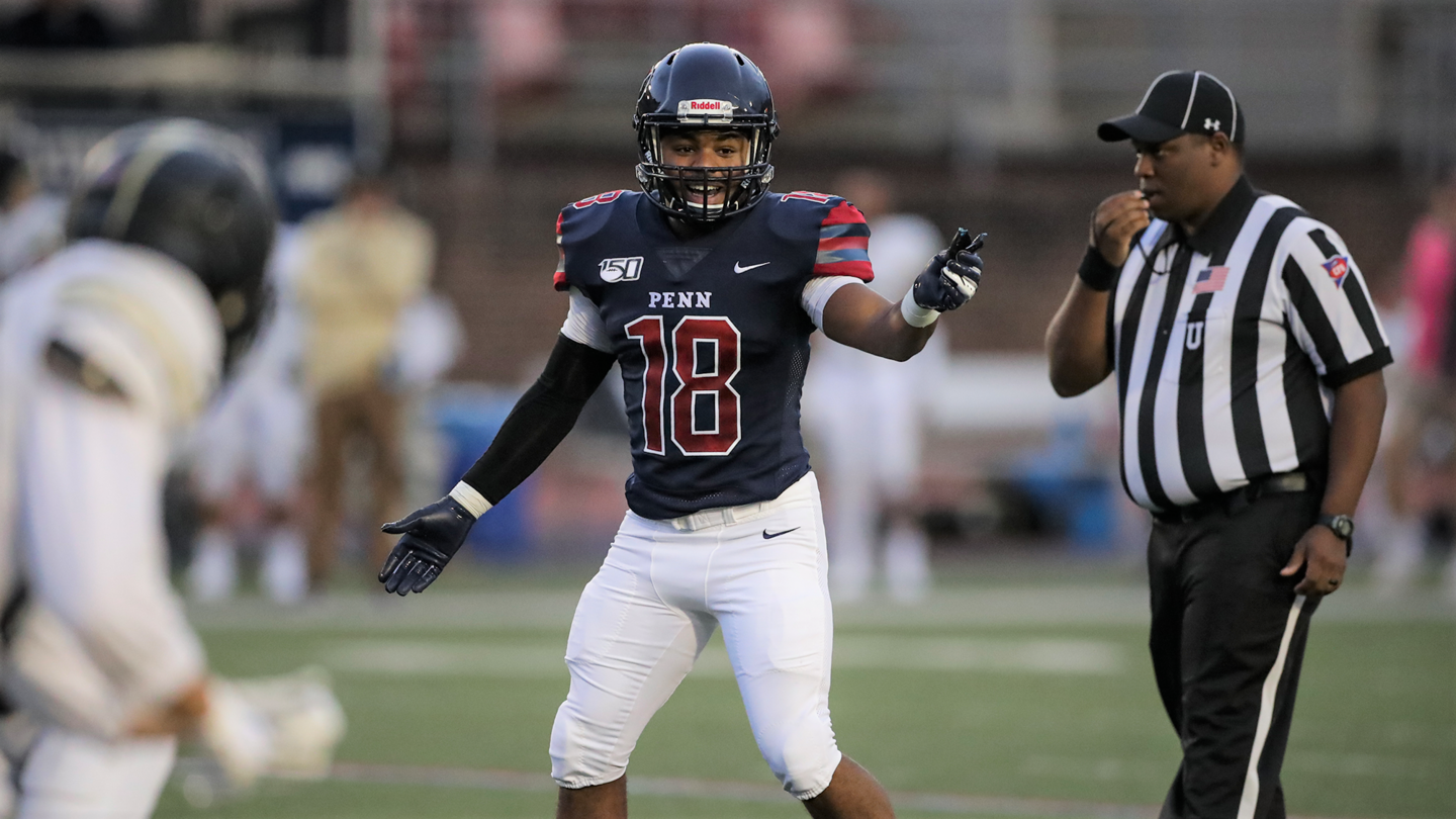 Junior linebacker Lewis Evans motions and smiles while on the field.