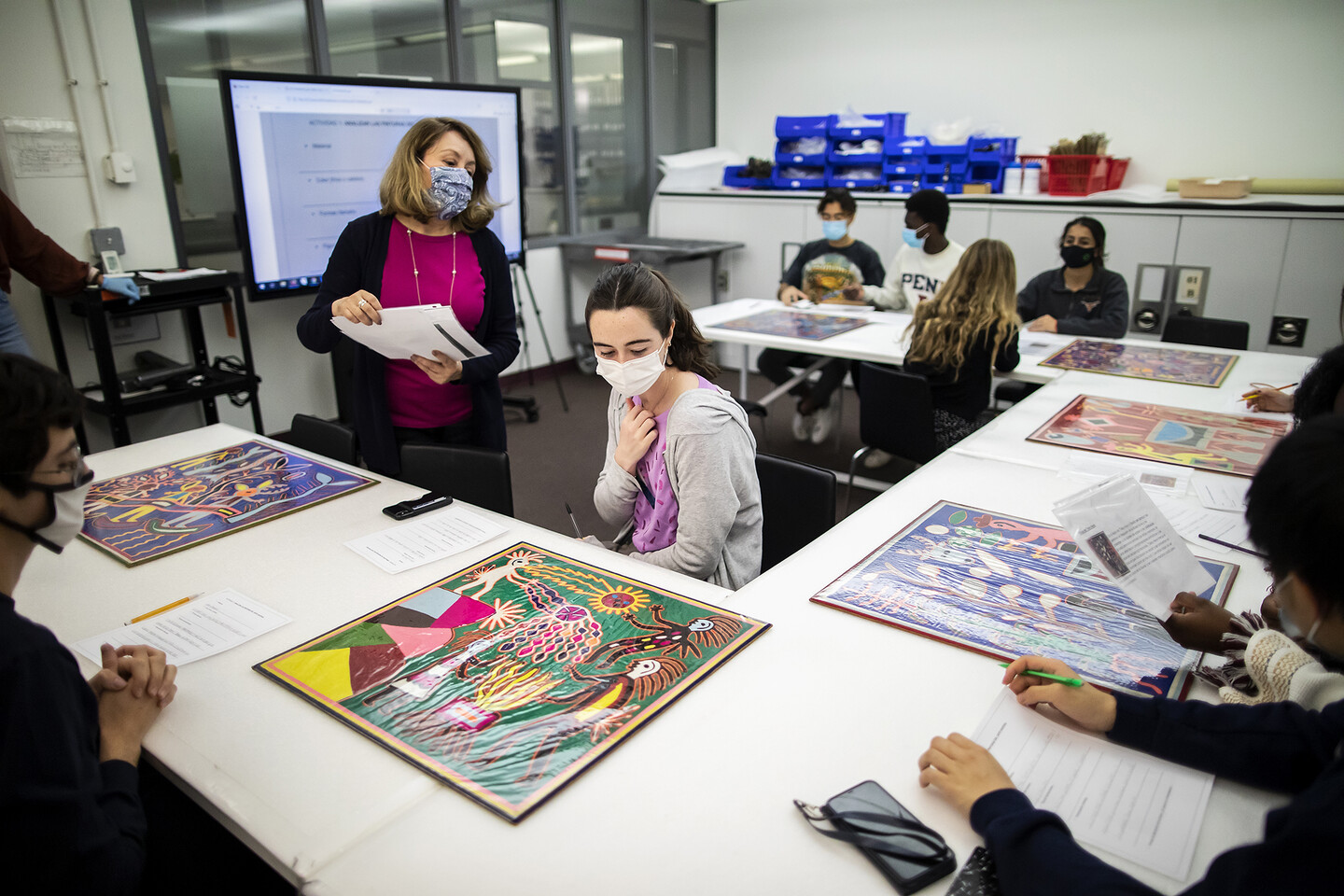 students looking at artworks on table 