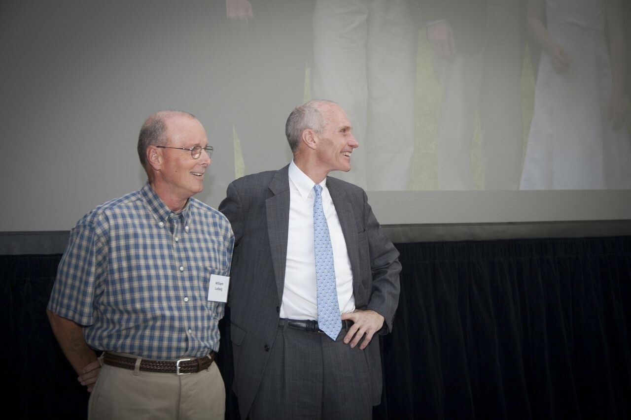 Two people stand closely together, smiling