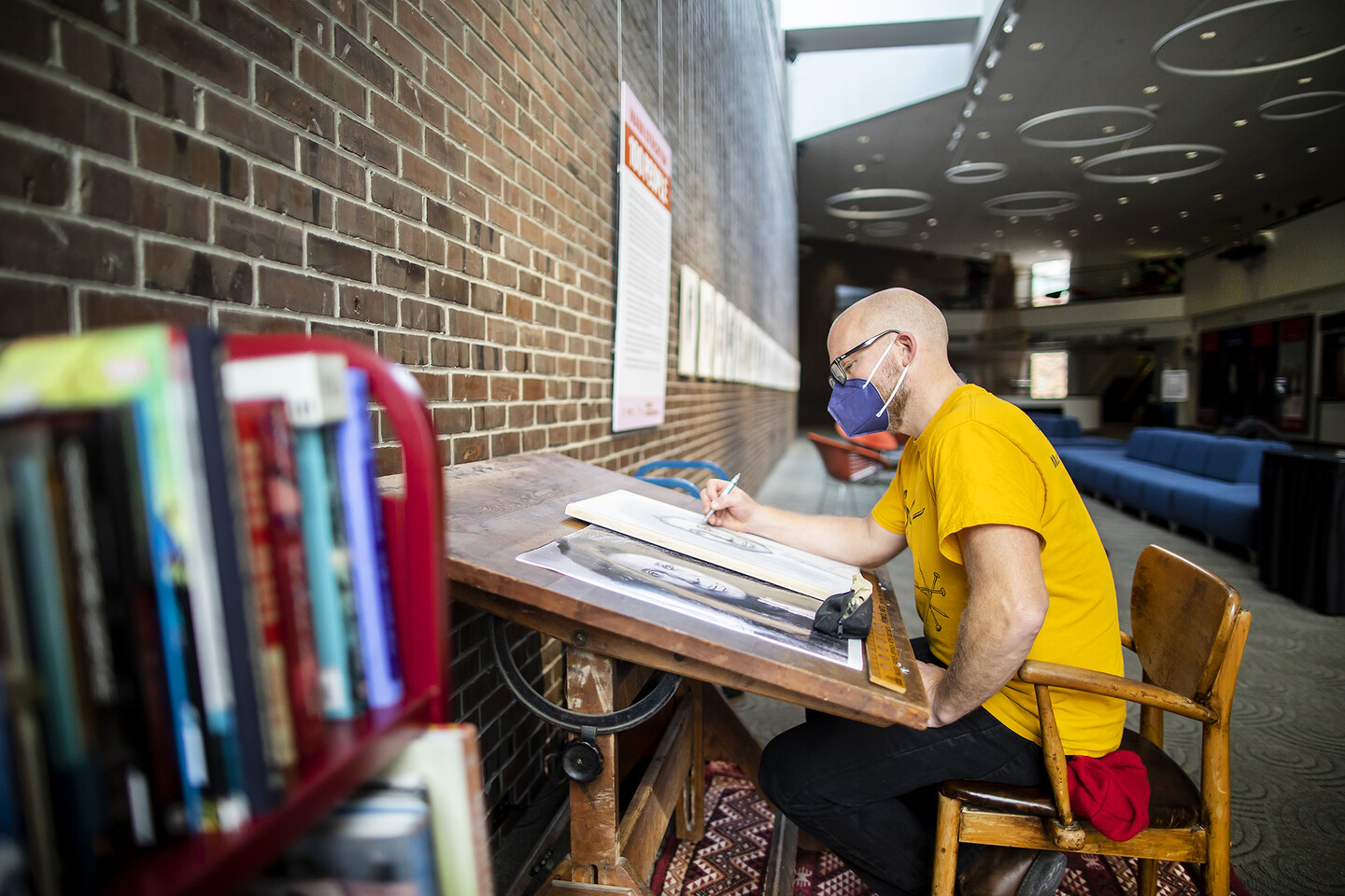 Books in foreground and Mark Stockton drawing in background