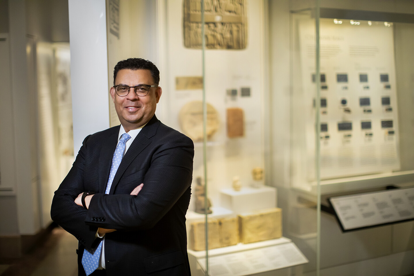 person standing in museum in front of cases with artifacts 