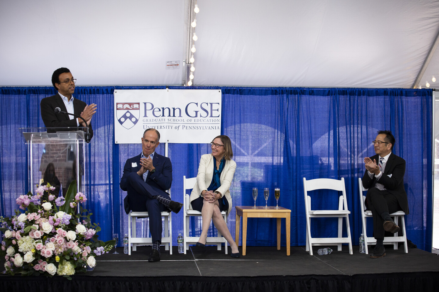 Four people on a stage clapping