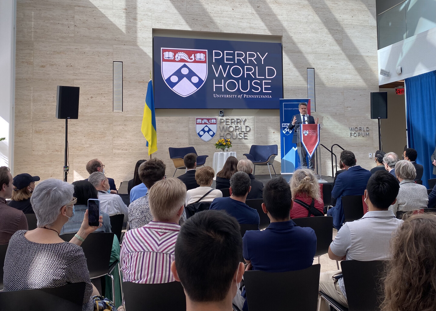 person speaking at podium with audience in view 