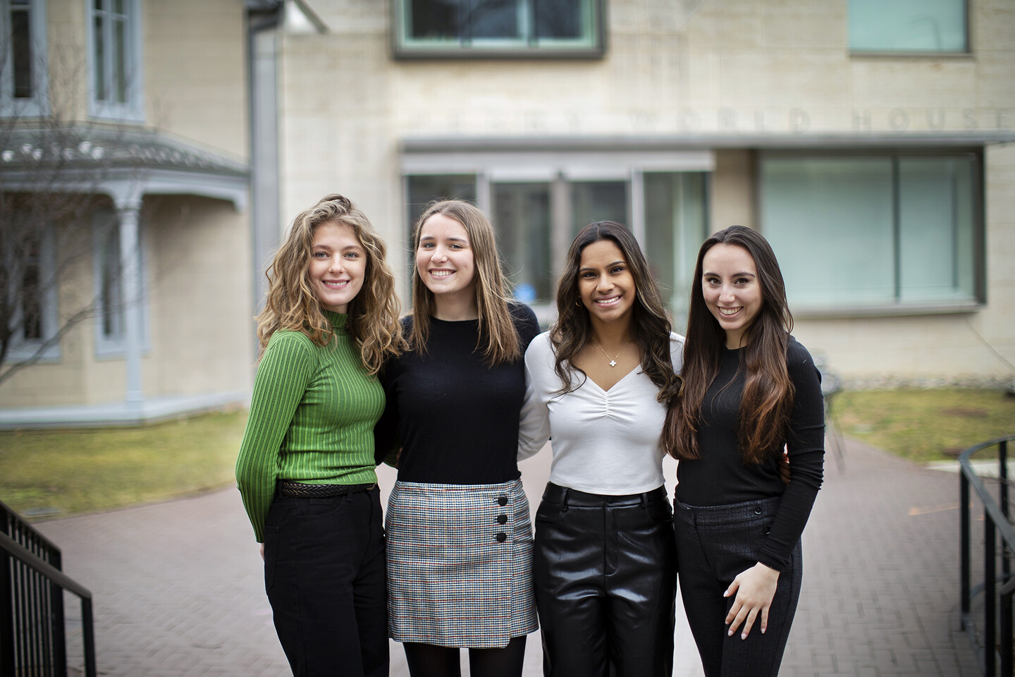 Four women stand in a row outside Perry World House