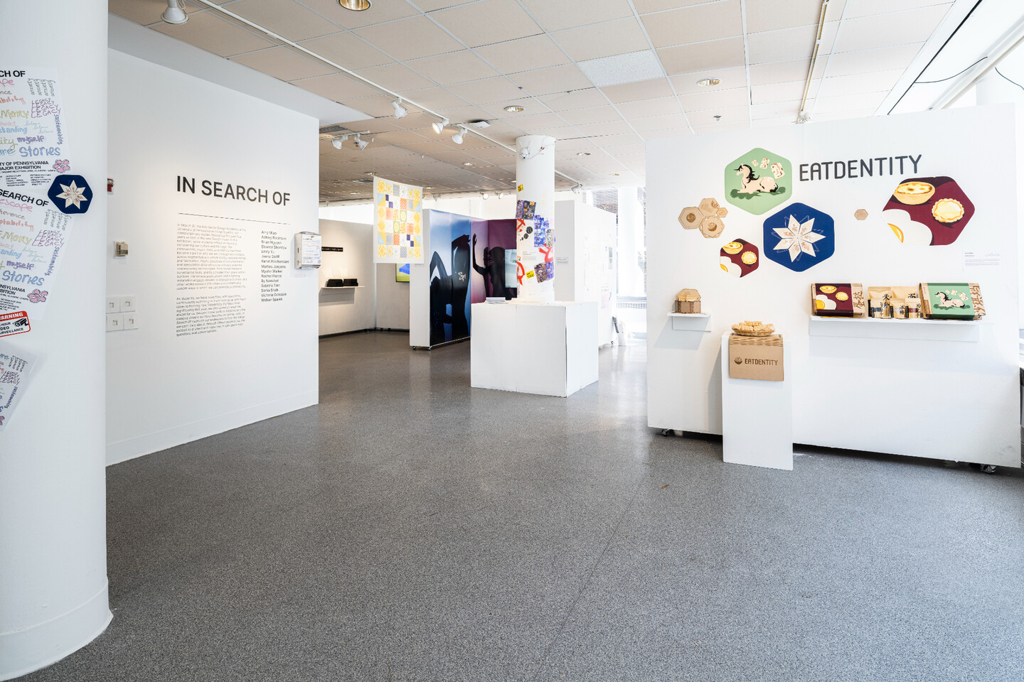 room with several displays of design projects with the entrance panel labeled with the theme in search of