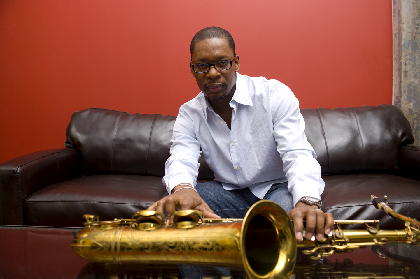 Ravi Coltrane on sofa holding saxophone