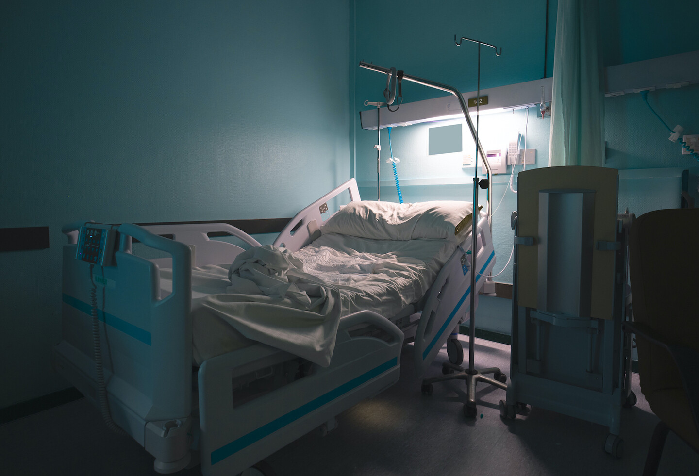 An empty hospital bed in a hospital room. 