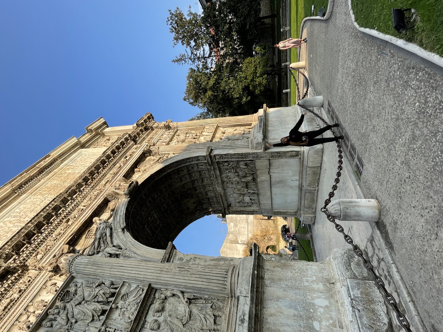 Rahman posts in front of a large arch with a frieze and columns depicted