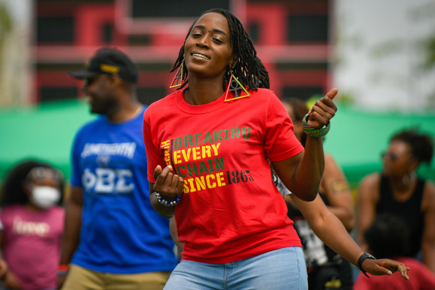 Person dancing at a Juneteenth celebration wearing a t-shirt that reads BREAKING EVERY CHAIN SINCE 1865.