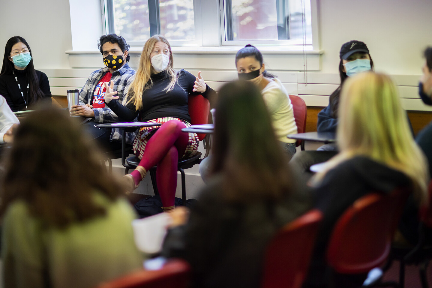 Whitney Trettien sitting among students in a classroom.