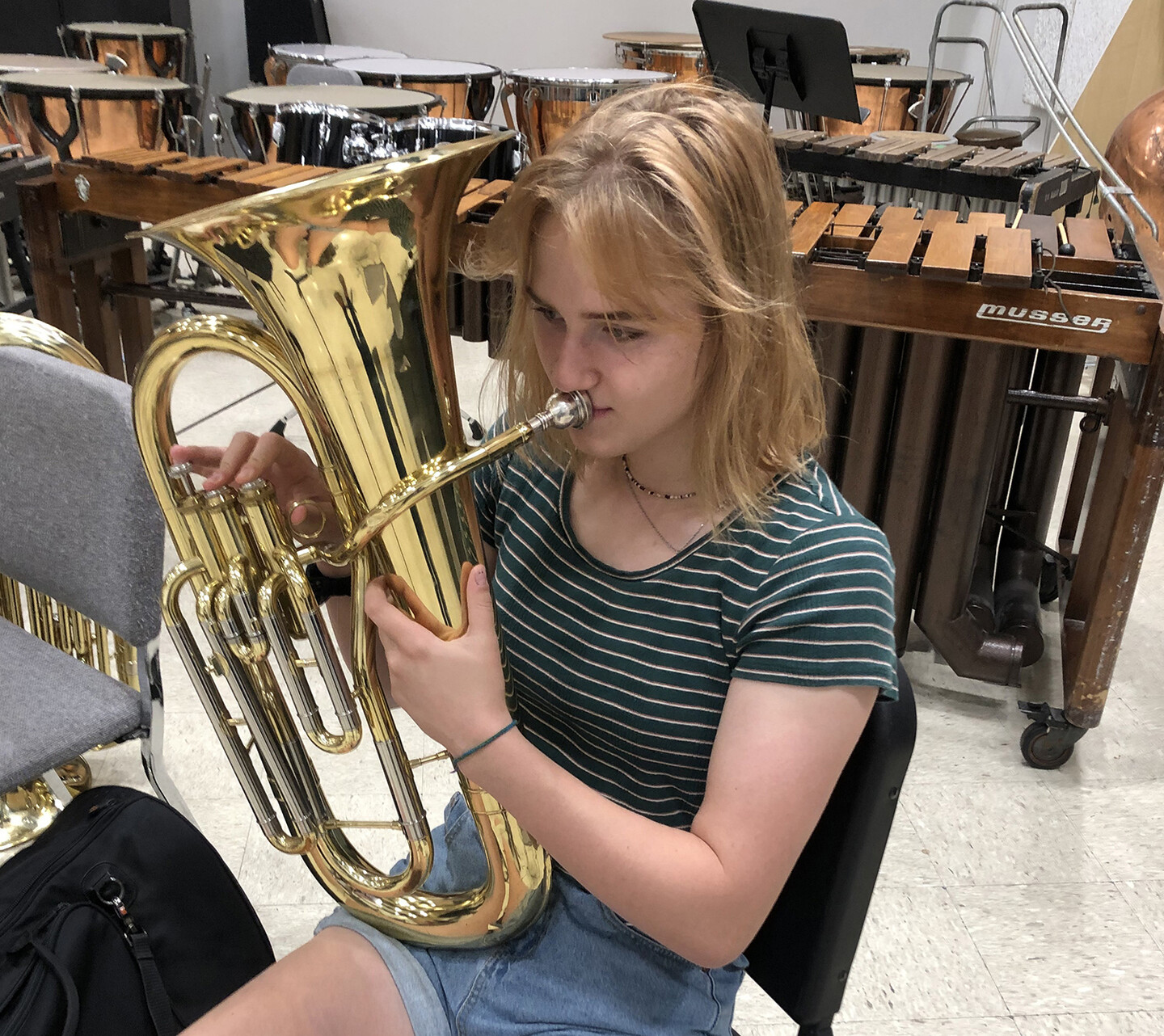 Chaily Derecskey seated, playing a tuba.