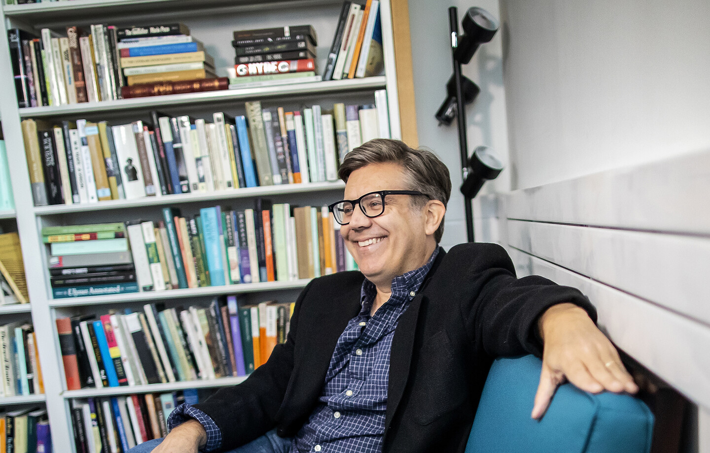 Jed Esty sitting on a sofa in front of a bookcase 