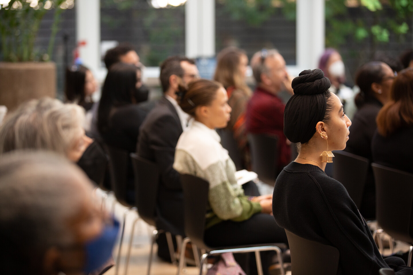 Rows of audience members listening to the speaker at Perry World House