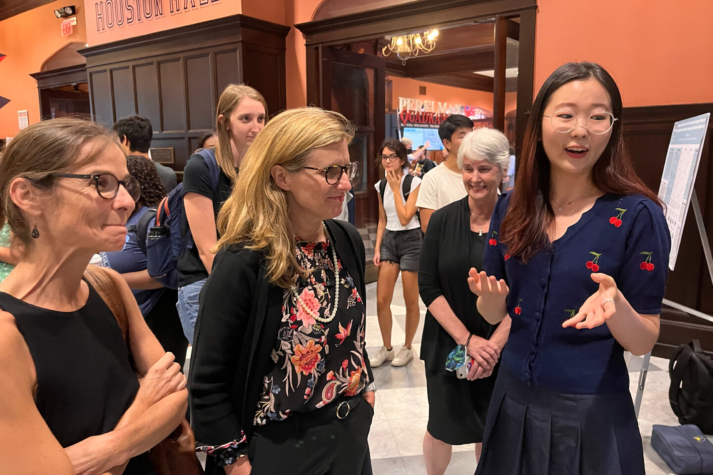 Liz Magill speaks with student about poster