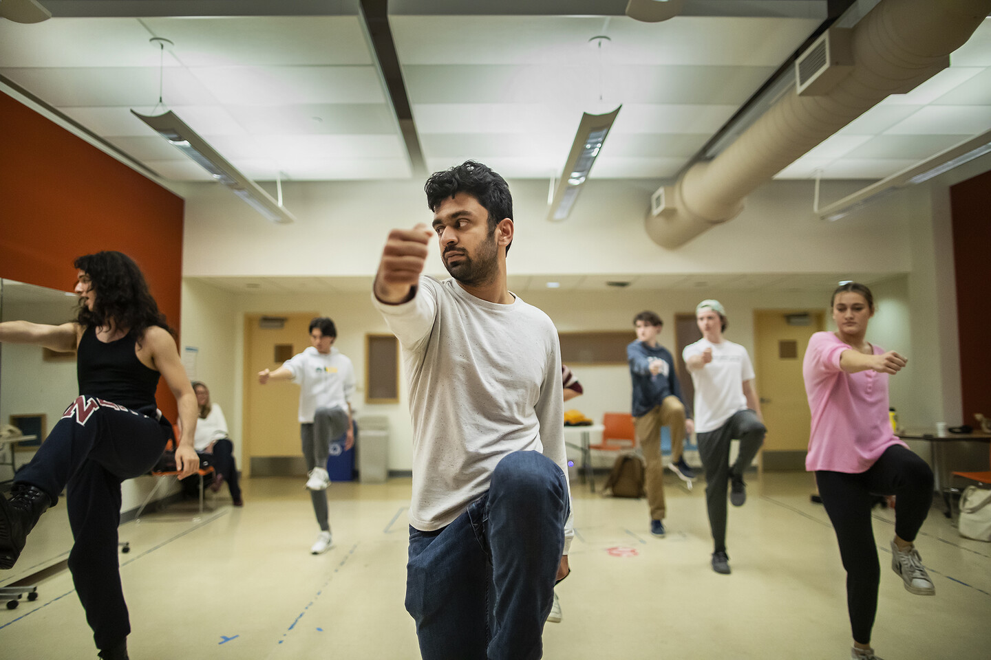 six students dancing in a rehearsal room 