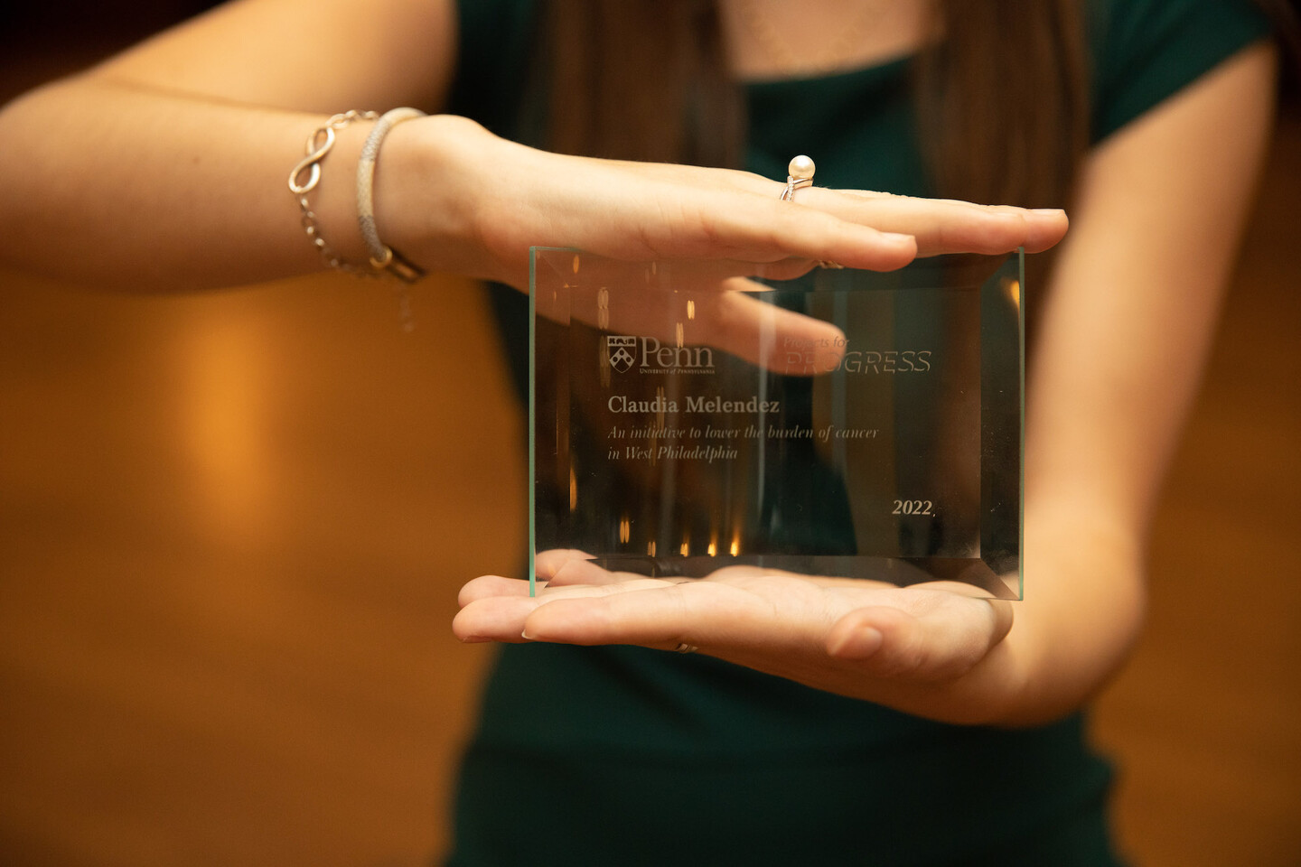 A woman holds up a glass award