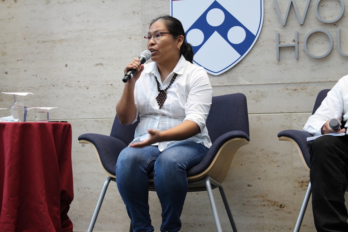Maya activist Cristina Coc speaks into a microphone on the Perry World House stage
