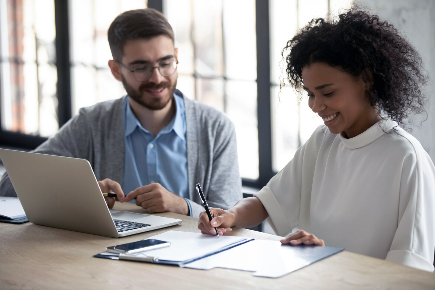 Two people sitting at a laptop.