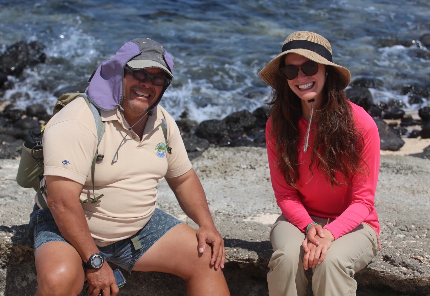 Ernesto Vaca and Victoria Moffit sit and smile by the water