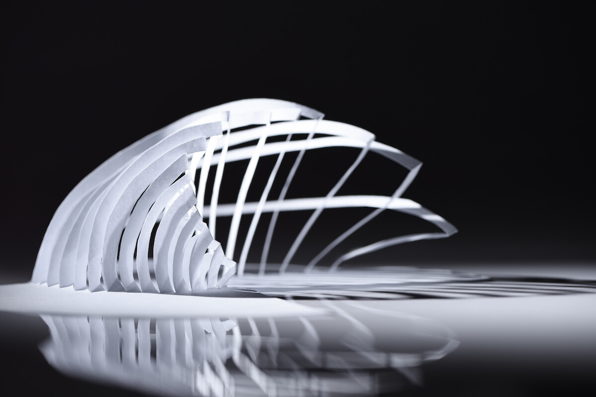 Curve lines seamless architecture pattern made of white folded paper. Geometric minimalist polygonal / polyhedron / geometric design. Close up. Paper architecture. Model / maquette. Paper cuttting.