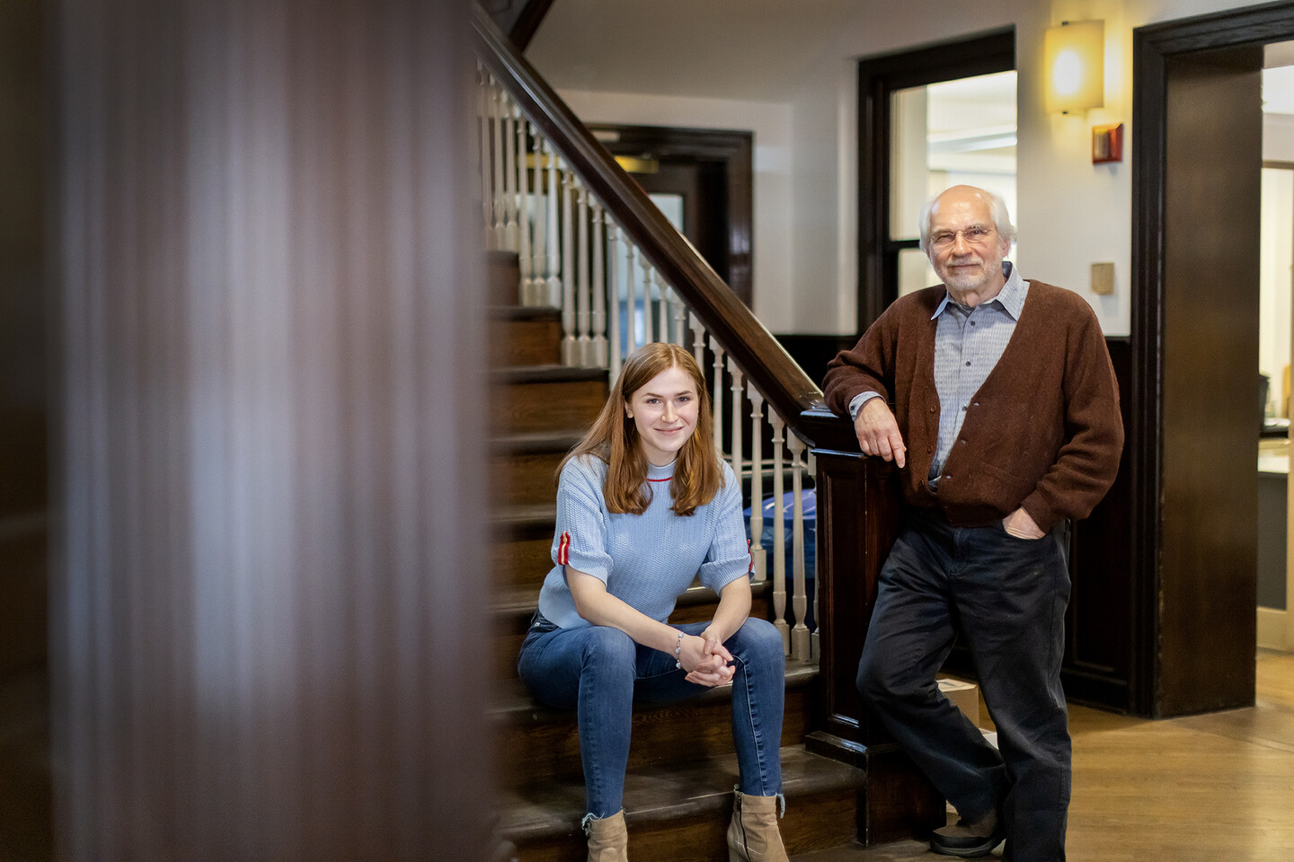 Aili Waller and Michael Leja standing at the base of a staircase in a historic building. 