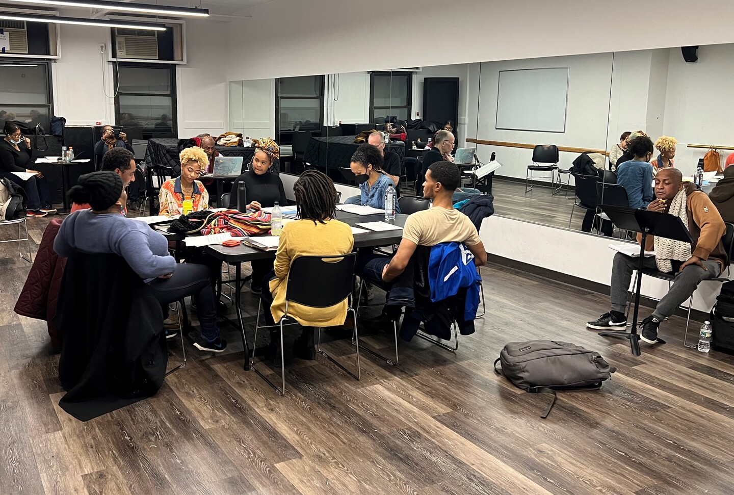 Group of people huddled around a table doing a reading