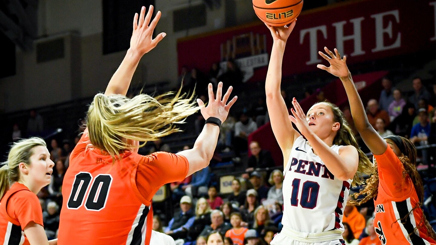 Mandy McGurk shoots a shot while surrounded by three defenders.
