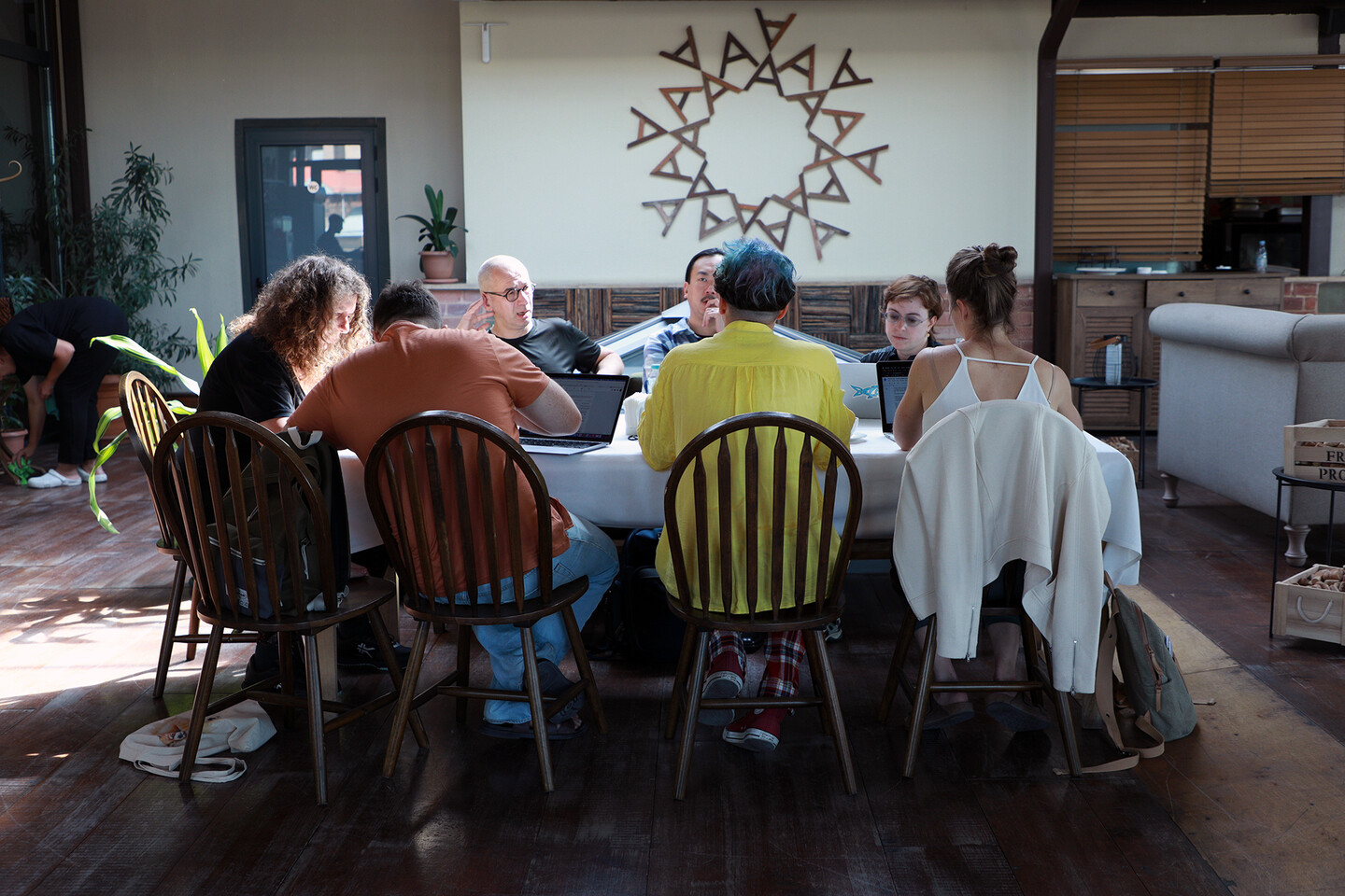 People sit around a table looking at laptops.