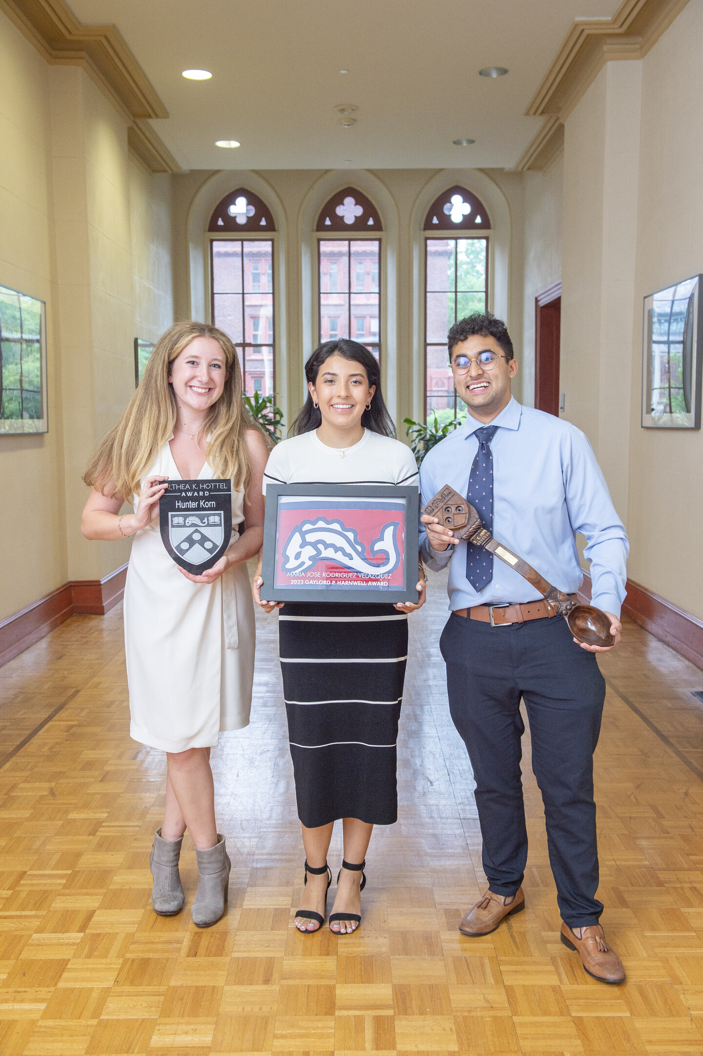 Three students pose with their various talismans of achievement
