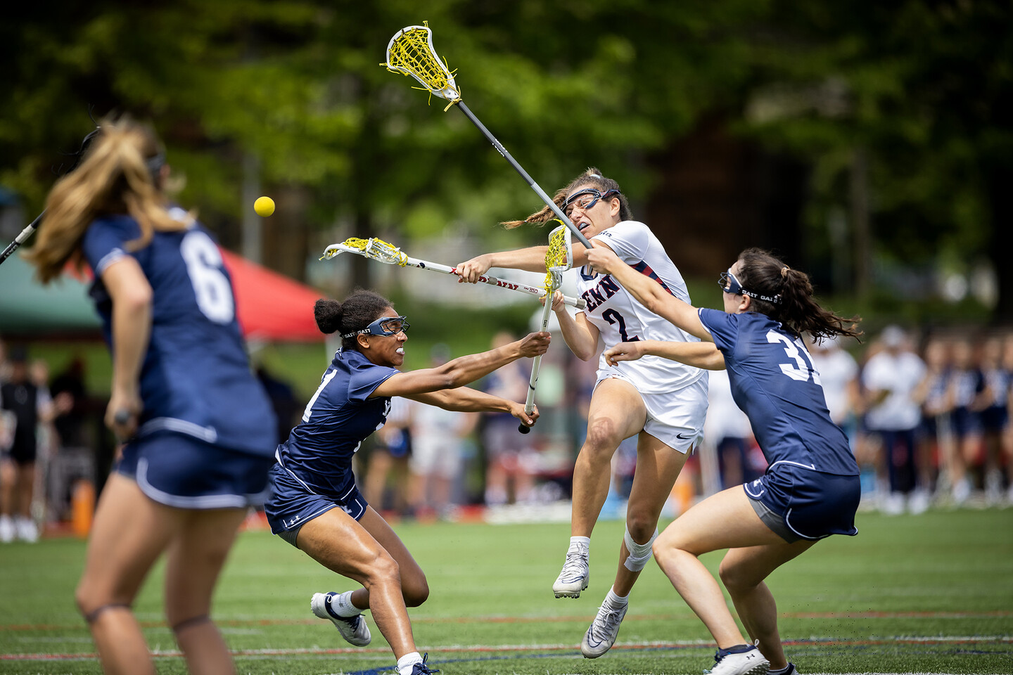 A women's lacrosse player shoots the ball during a game