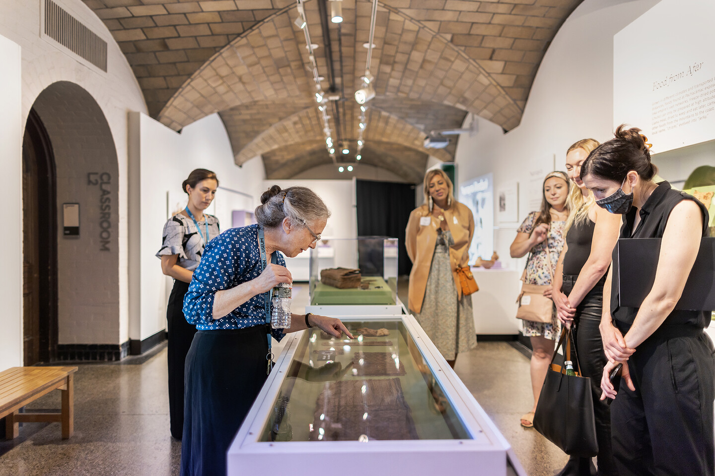six people looking at a display case in a museum