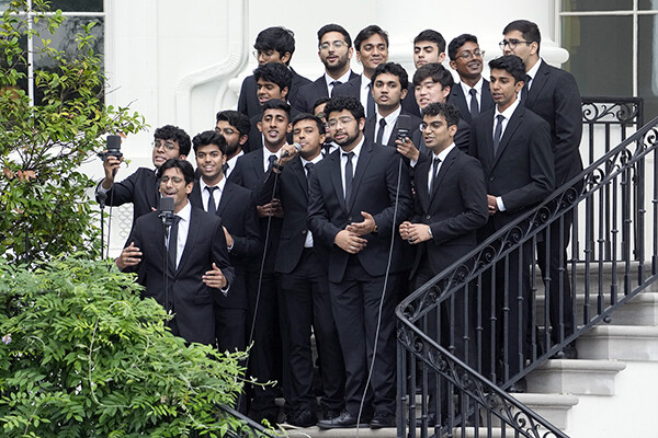 19 singers standing on steps