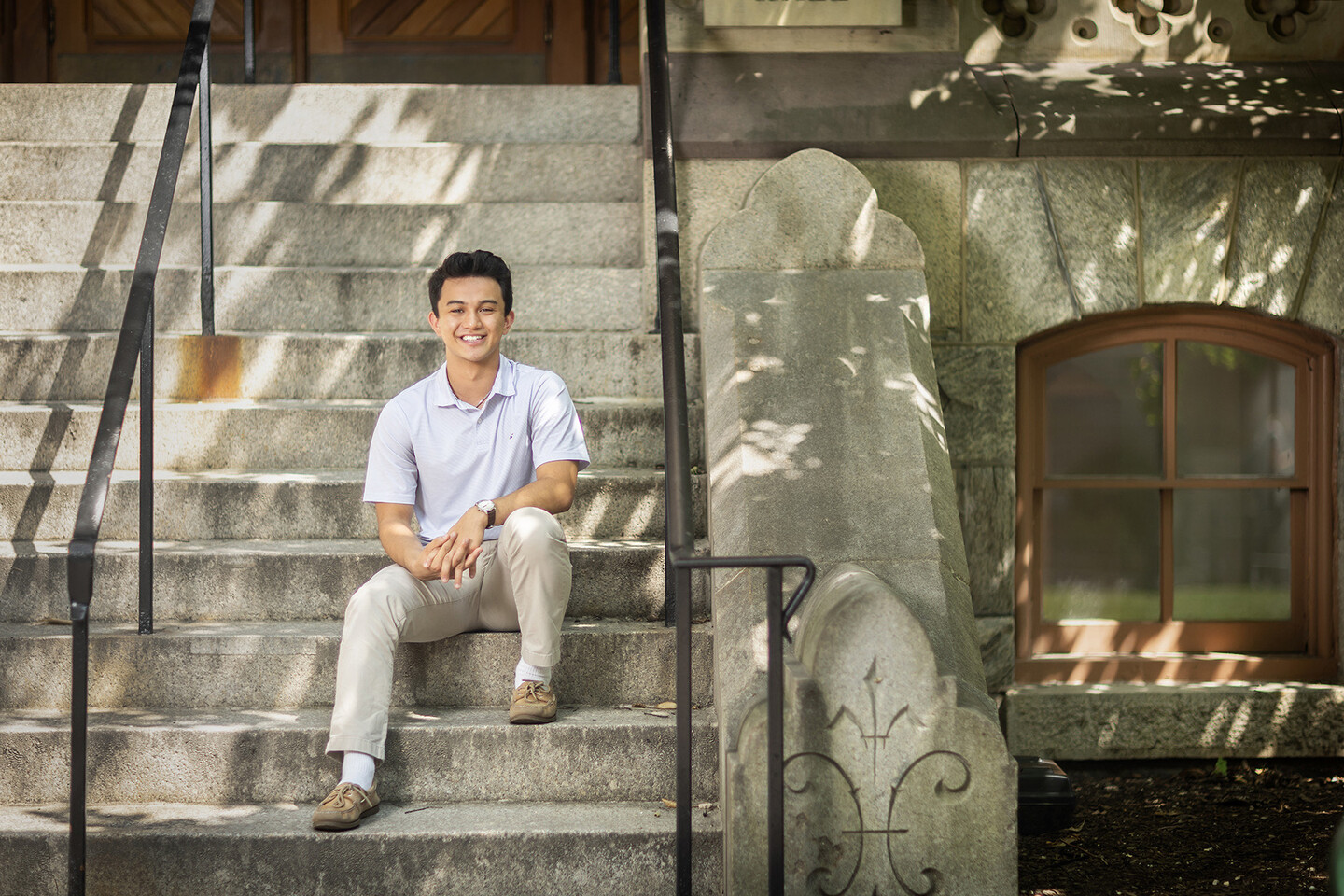peyton akiba sitting on the steps of a university building