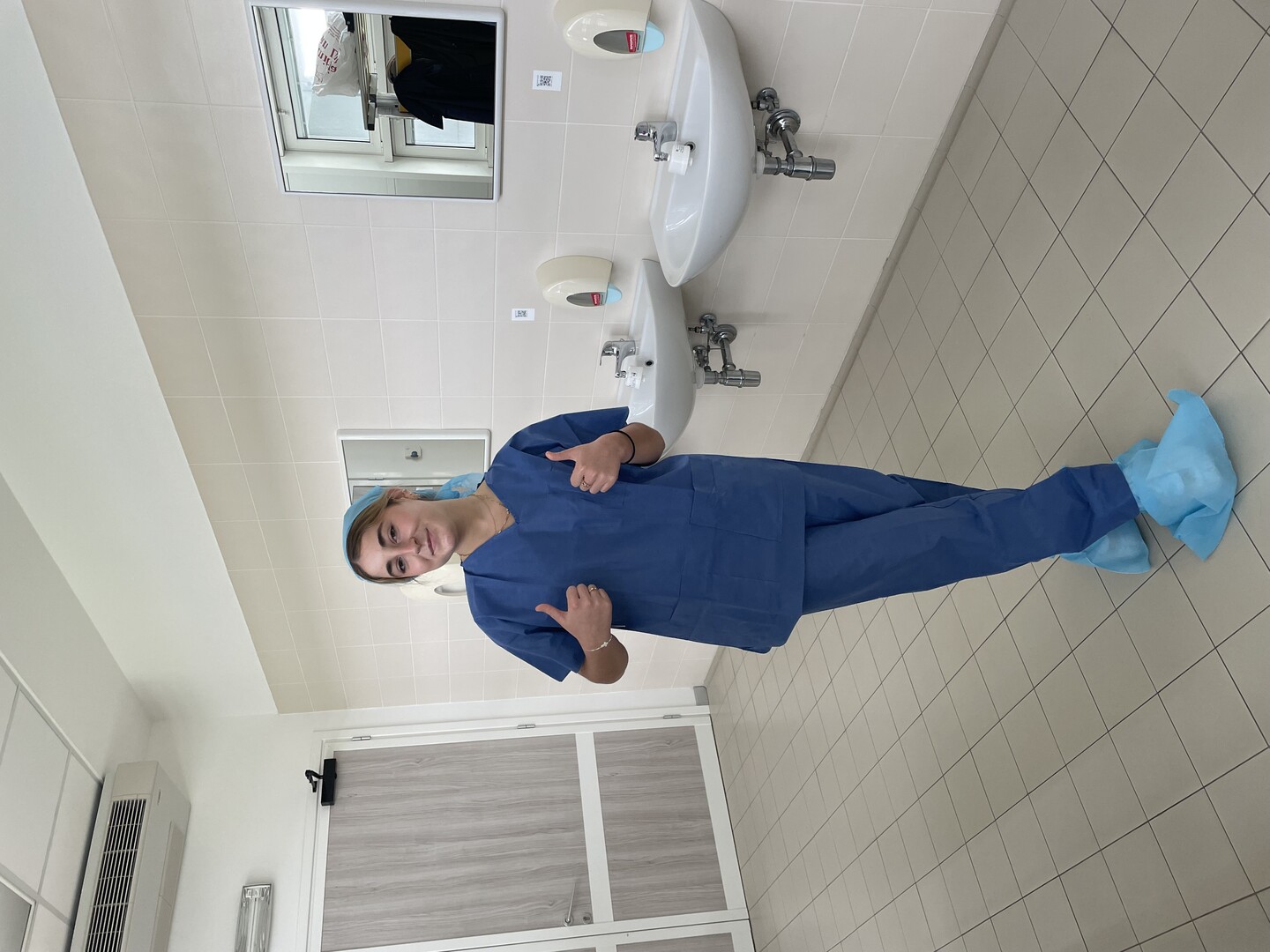 Julia Ognibene gives two thumbs up next to a series of sinks