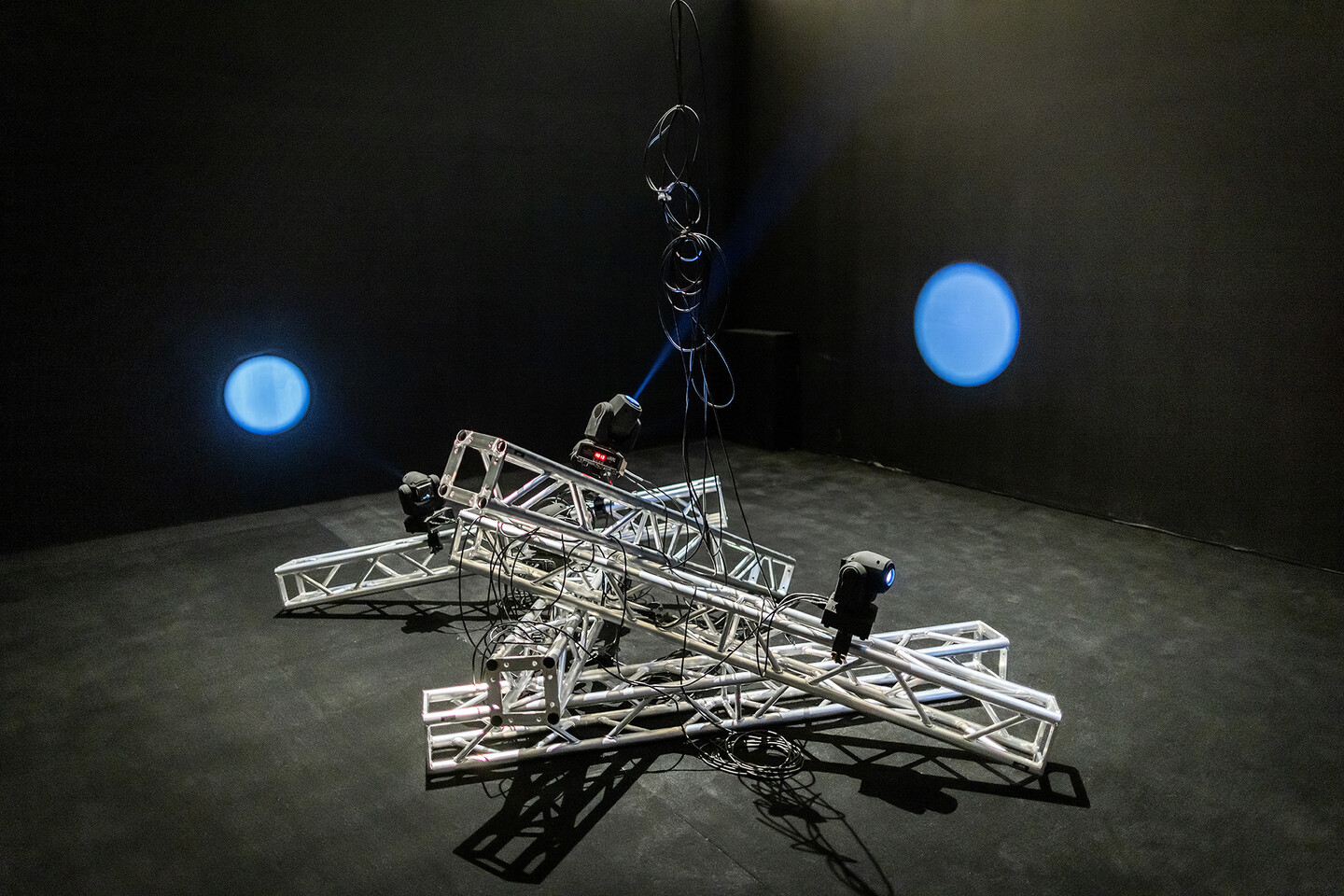 Metal beams piled on top of one another with spotlights on top of them. 