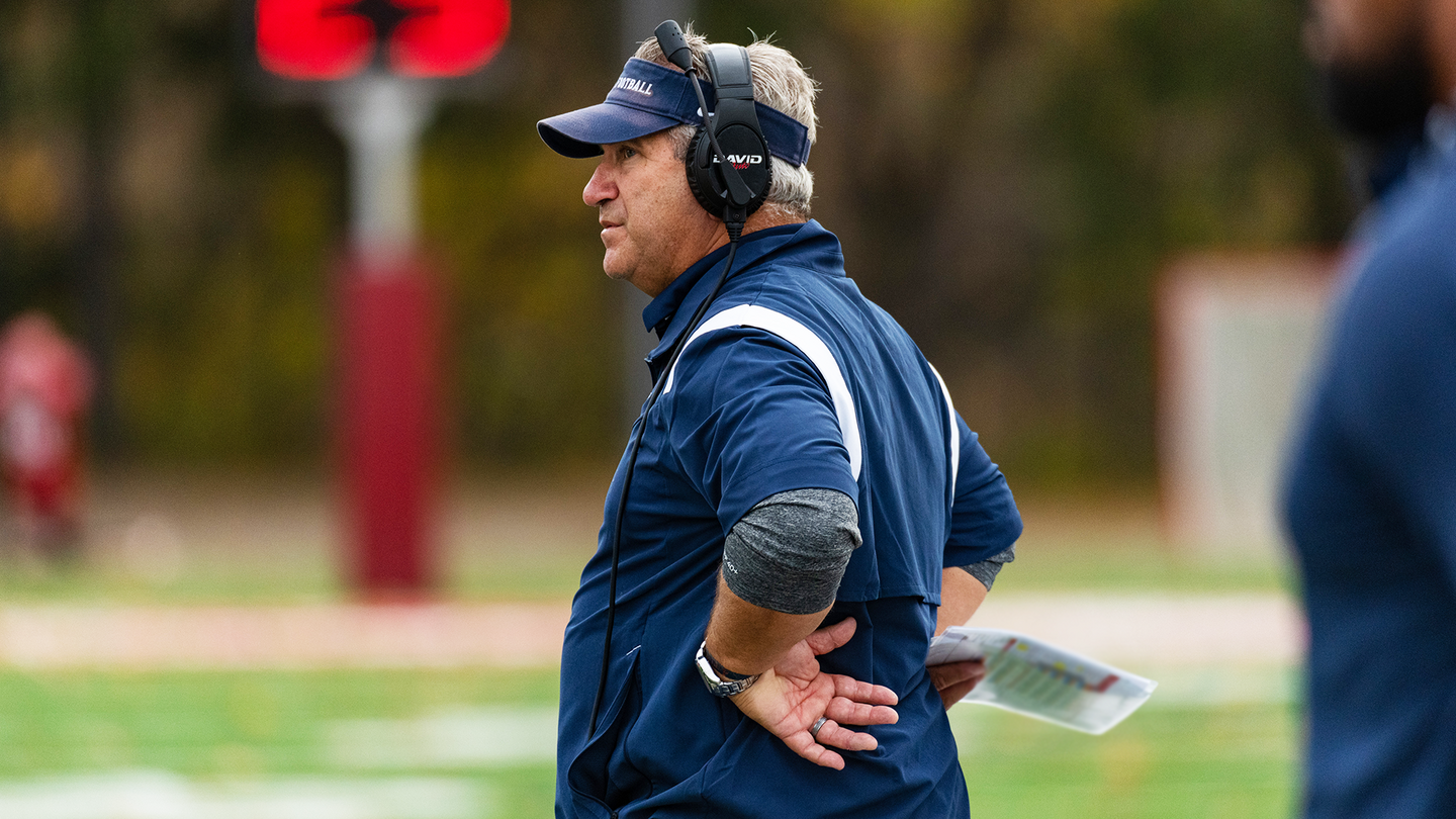 Ray Priore stands on the sidelines with his hands on his hips during a game.