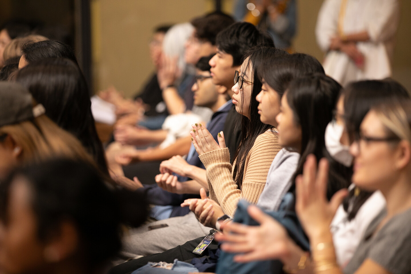 A row of seated students clap