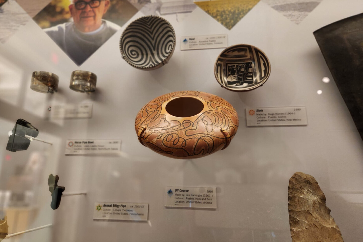 clay jar in museum case surrounded by other clay works