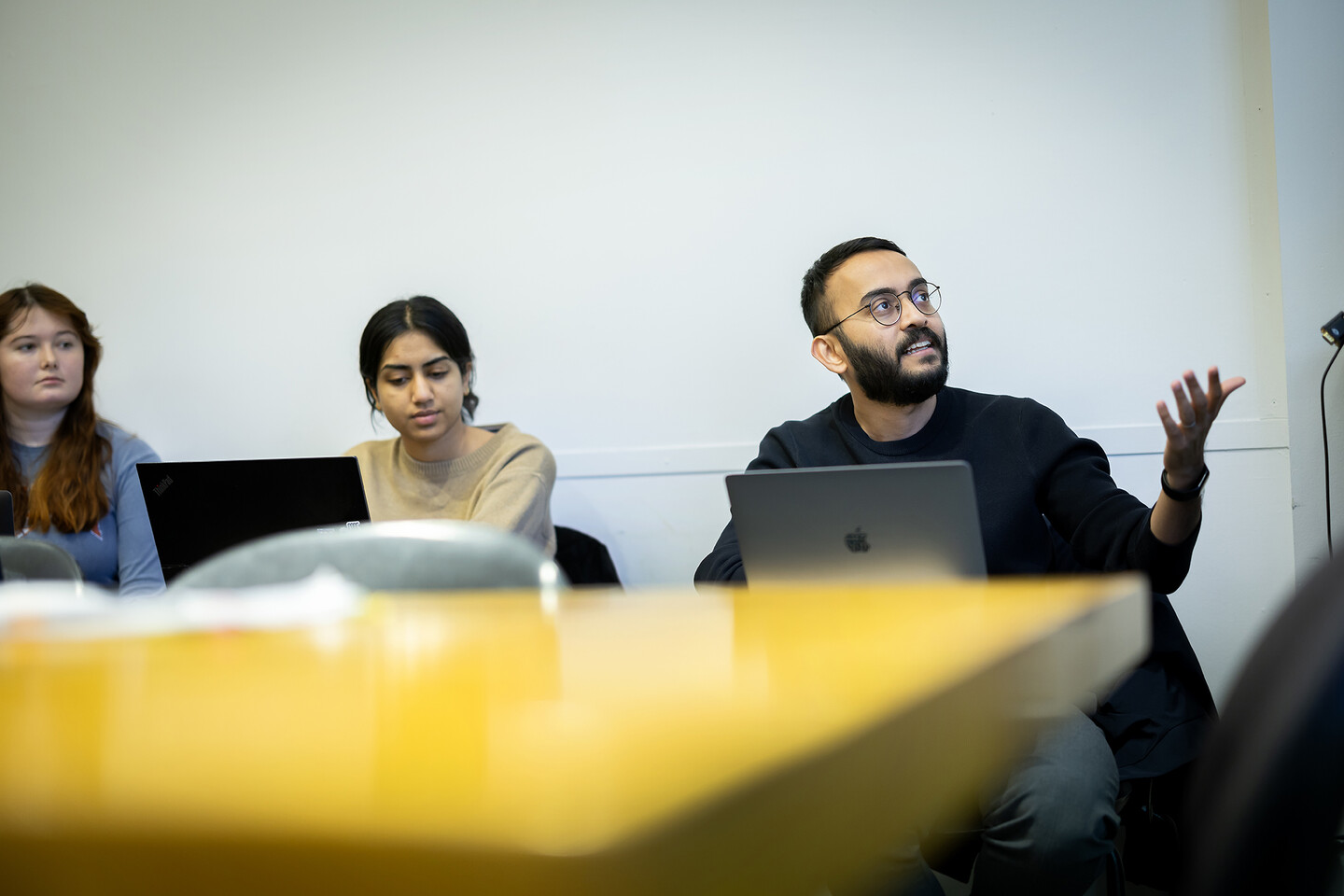 Akhil Veetil gestures while speaking to a presenting student (not pictured)