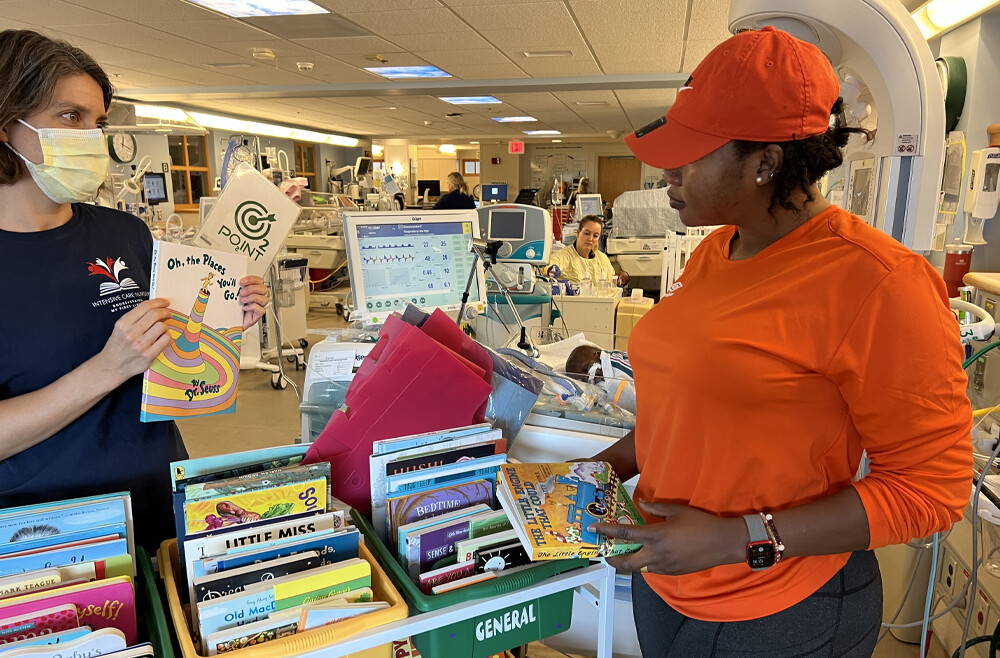 Boura Zerbo (right) and Whitney Zachritz peruse the book selection cart.